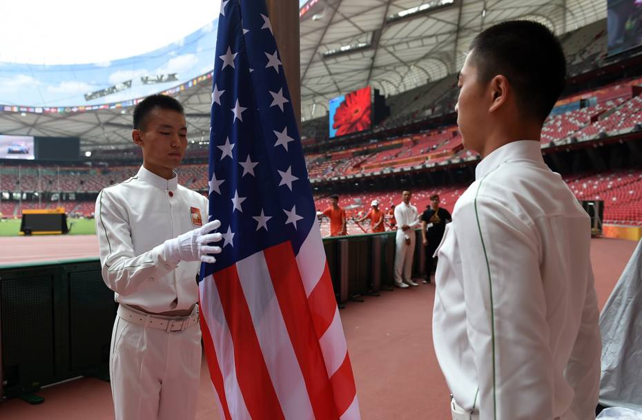 Guanti bianchi, uniforme immacolata e sguardo fiero. I momenti della preparazione della bandiera statunitense per la cerinonia inaugurale del Campionato del mondo di Atletica di Pechino. (Afp)